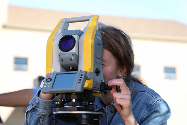 Girl using surveying equipment