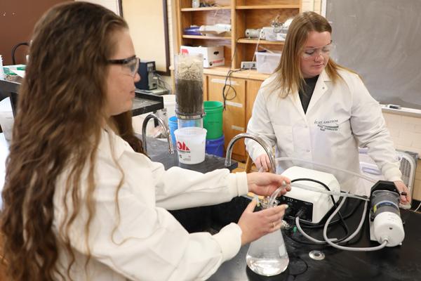 两个女学生在实验室里使用环保设备