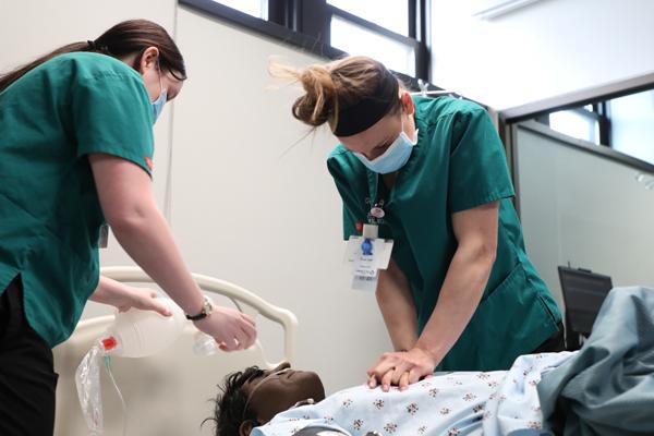 Nursing students performing CPR on a mannequin