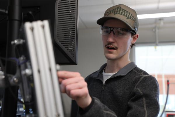 机械 engineering student pointing at a computer screen